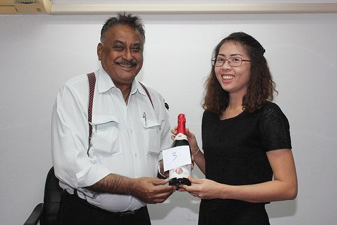 Peter Malhotra presents Nutsara Duangsri with her lucky draw prize - delicious apple juice.