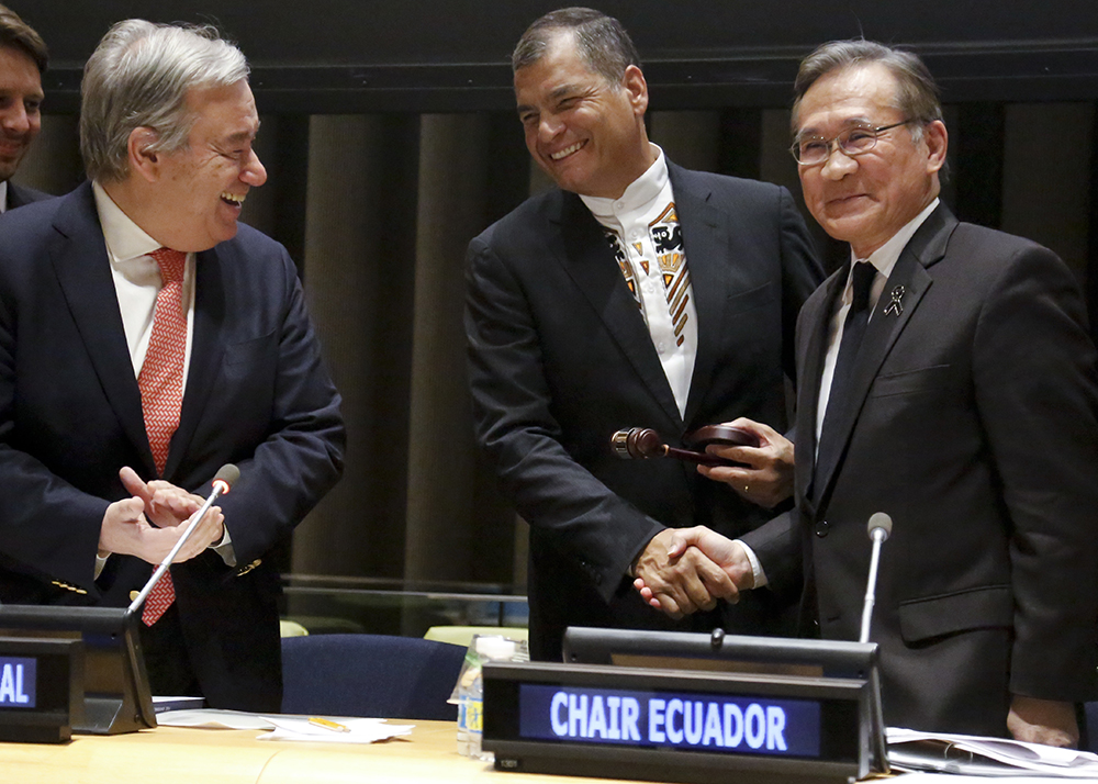 United Nations Secretary General António Guterres, left, observes as Thai Foreign Minister Don Pramudwinai, right, hands over the chairmanship of the United Nations Group of 77 to Ecuador's President Rafael Correa, center, Friday Jan. 13, 2017 at U.N. headquarters. (AP Photo/Bebeto Matthews)
