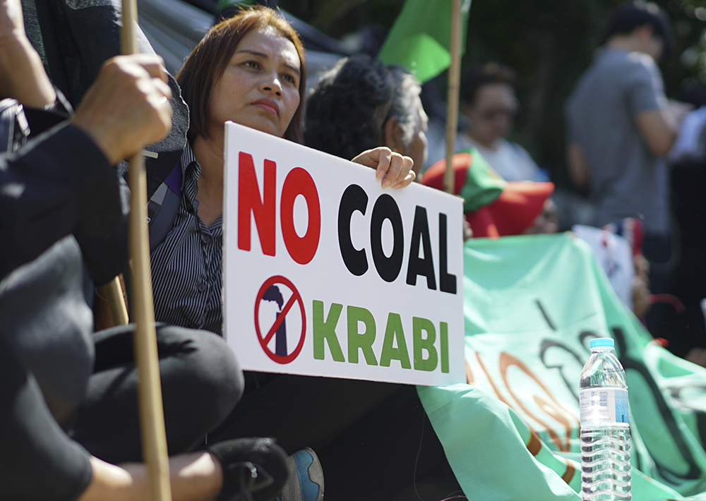 A woman holds up a sign against a proposed coal-fired plant on Thailand's coast, in Bangkok, Thailand, Feb. 17, 2017. (AP Photo/Dake Kang)