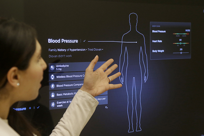 In this Jan. 10, 2017 photo, Dr. Aaliya Yaqub points to a large monitor while giving a demonstration of medical checkup at a Forward medical office in San Francisco. (AP Photo/Jeff Chiu)