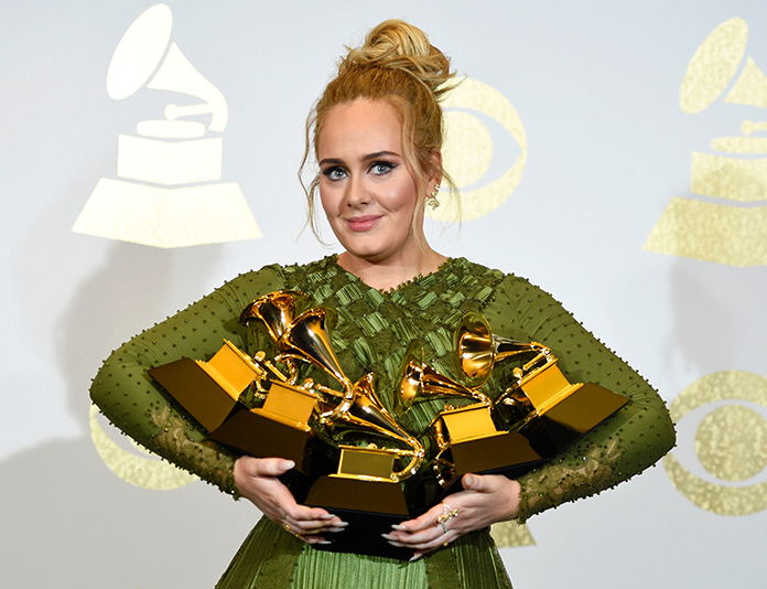 Adele poses in the press room with the awards for album of the year for "25", song of the year for "Hello", record of the year for "Hello", best pop solo performance for "Hello", and best pop vocal album for "25" at the 59th annual Grammy Awards at the Staples Center on Sunday, Feb. 12, in Los Angeles. (Photo by Chris Pizzello/Invision/AP)