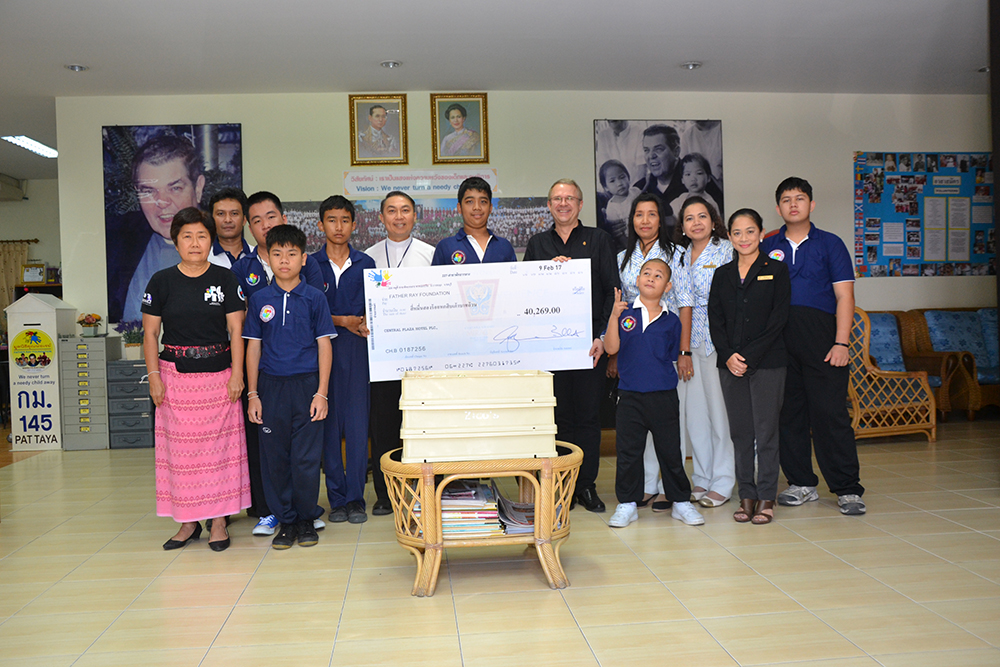 General Manager Andre Brulhart presents a check for 40,269 baht to Father Ray Vice President Rev. Pattarapong Srivorakul Feb. 21.
