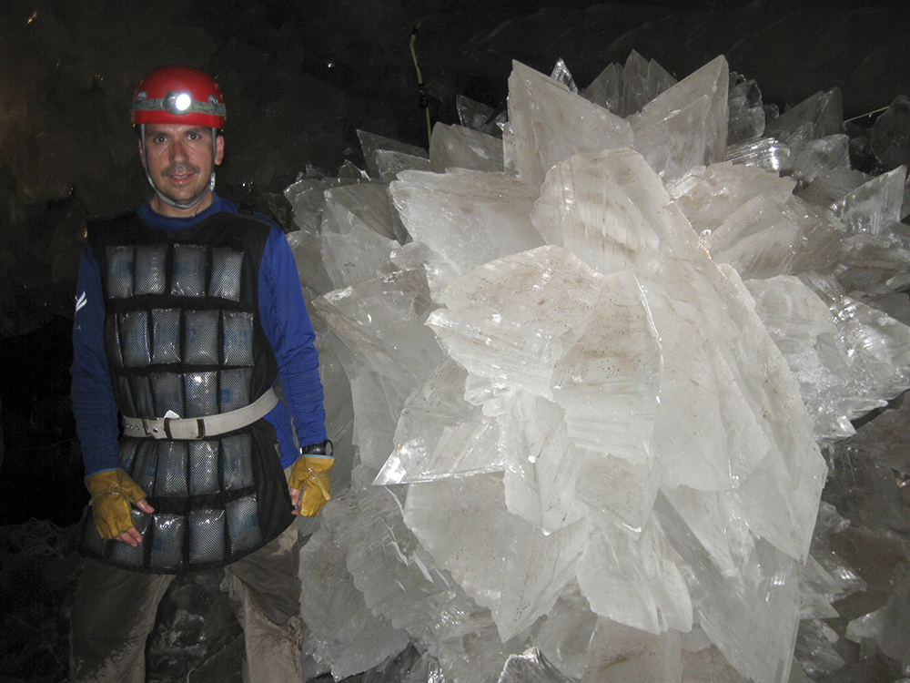 Mario Corsalini stands near to a gypsum rosette crystal. In a Mexican cave system so beautiful and hot that it is called both Fairyland and hell, scientists have discovered life trapped in crystals that could be 50,000 years old. (Mike Spilde via AP)