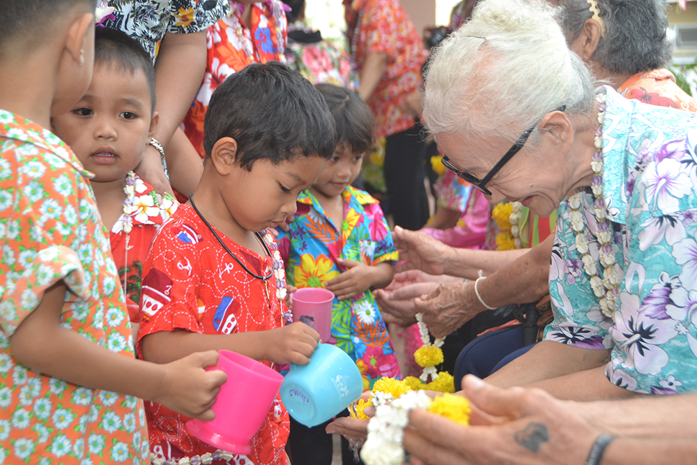 Young children concentrate hard to make sure they perform the ceremony correctly, much to the delight of their benefactors.