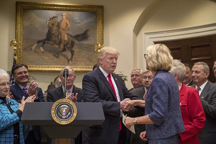 President Donald Trump greets Education Secretary Betsy DeVos before signing the Education Federalism Executive Order, Wednesday, April 26, 2017, in the Roosevelt Room of the White House in Washington. (AP Photo/Andrew Harnik)