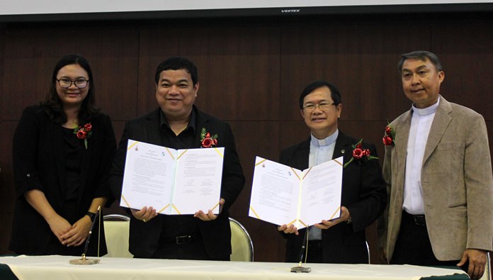 (L to R) Eakarin Sangdhammarath and Kritchon Phumkittipit sign an agreement with Rev. Picharn Jaiseri and Rev. Peter Pattarapong Srivorakul to develop a new electric wheelchair and customized cushions for the disabled.