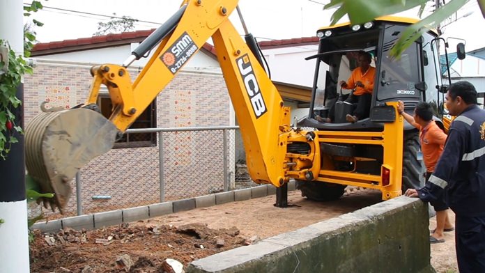 Workers used heavy machinery to knock down a barrier and dig out a trench to let the trapped water escape.