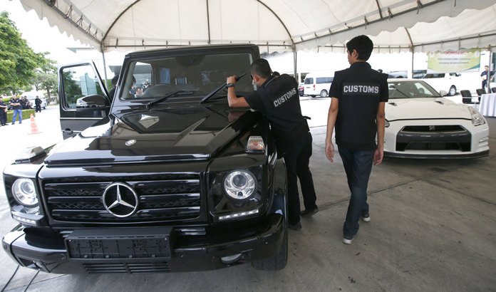 Thai Customs officers check seized Mercedes GLE 350, left, and Nissan GTR during a press conference at the customs office in Bangkok, Thailand, Friday, June 30, 2017.(AP Photo/Sakchai Lalit)