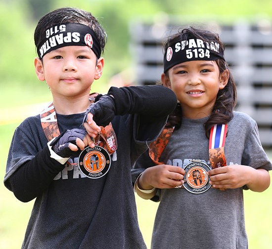 Two young Spatans proudly show off their race medals.