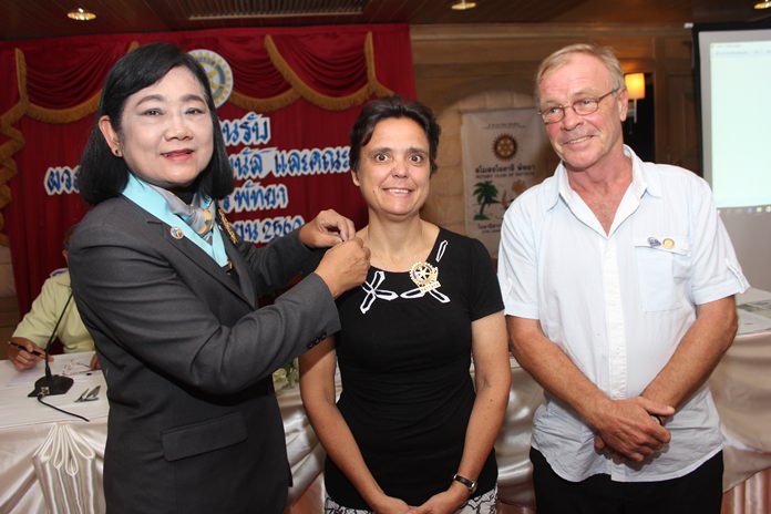 DG Onanong inducts Margaret Grainger into the Rotary Club of Pattaya as her proposer Stephen Devereux looks on.