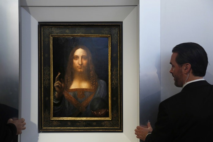 Security guards open a door to reveal “Salvator Mundi” by Leonardo da Vinci during a news conference at Christie’s in New York, Tuesday, Oct. 10. (AP Photo/Seth Wenig)
