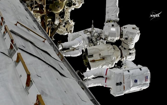 In this frame from NASA TV, Astronauts Mark Vande Hei and Randy Bresnik, bottom, work on the International Space Station on Thursday, Oct. 5, 2017. The astronauts went out on a spacewalk to give the International Space Station’s big robot arm a new hand. (NASA TV via AP)
