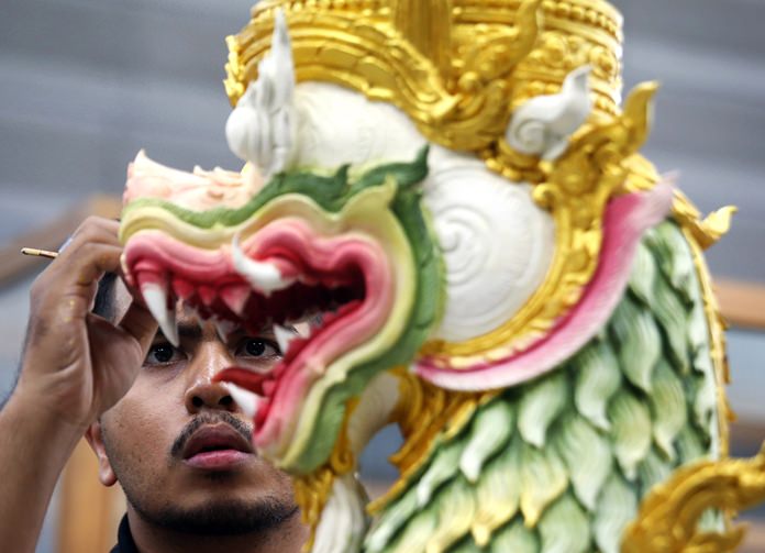 An artist paints a creature from ancient epics to decorate the royal crematorium and funeral complex. (AP Photo/Sakchai Lalit)