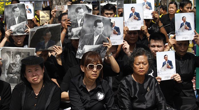 Mourners hold aloft the portraits of late Thai King Bhumibol Adulyadej during his funeral procession and royal cremation ceremony, in Bangkok, Thursday, Oct. 26, 2017. Tearful Thais clad in black mourned on Bangkok’s streets or at viewing areas around the nation Thursday as elaborate funeral ceremonies steeped in centuries of royal tradition were held for King Bhumibol following a year of mourning. (AP Photo/Sakchai Lalit)