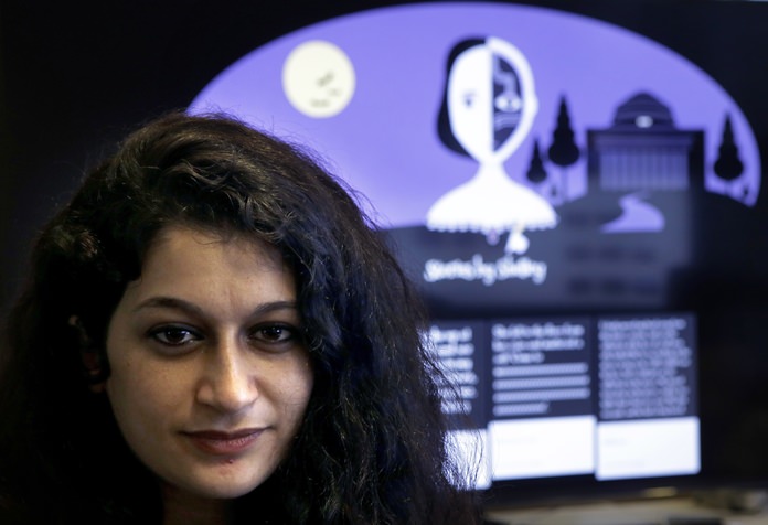 Co-creator of a fiction-writing ‘chatbot,’ Massachusetts Institute of Technology postdoctoral associate Pinar Yanardag sits for a photograph in front of a graphic from the home page of the site called “Shelley.” (AP Photo/Steven Senne)