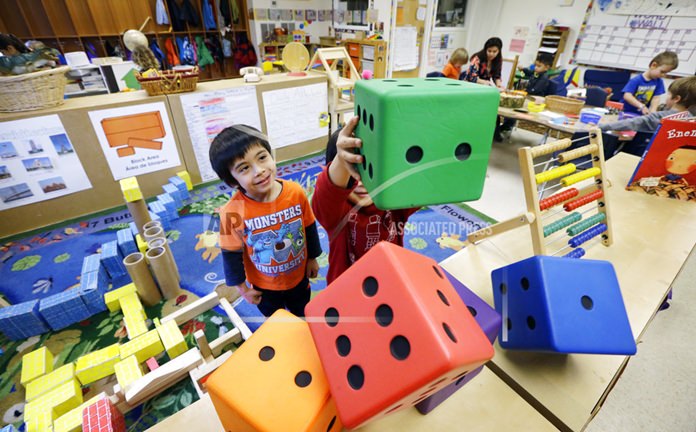 In this photo taken Feb. 12, 2016, Daniel O’Donnell, left, looks on as William Hayden sends large blocks flying at the Creative Kids Learning Center, a school that focuses on pre-kindergarten for 4- and 5-year-olds, in Seattle. (AP Photo/Elaine Thompson, File)