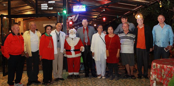 Rotarians and guests pose with Santa Claus at Prem’s Christmas party.