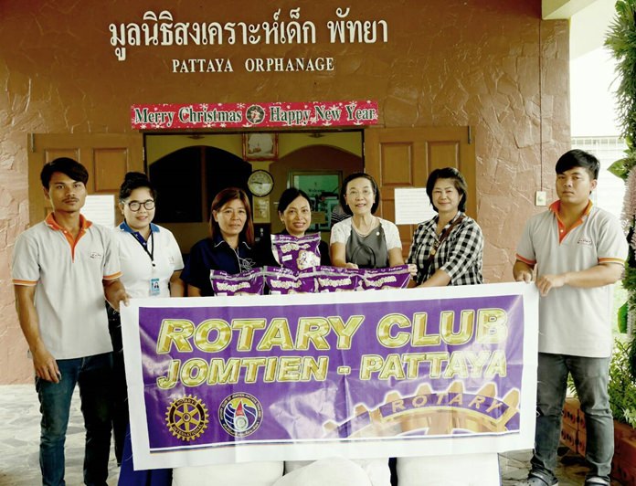 Radchada Chomjinda (3rd right) receives the rice on behalf of the Pattaya Orphanage from Nachlada Nammontree (center) and Ket Battaglino (3rd left).