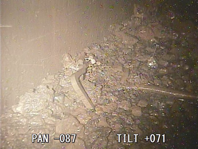 A photo taken by a robotic probe provided by the International Research Institute for Nuclear Decommissioning, Friday, Jan. 19, 2018, shows a part of what is believed to be the handle of the fuel rods container and melted fuel in small lumps scattered on a structure below the Fukushima reactor core. (International Research Institute for Nuclear Decommissioning via AP)