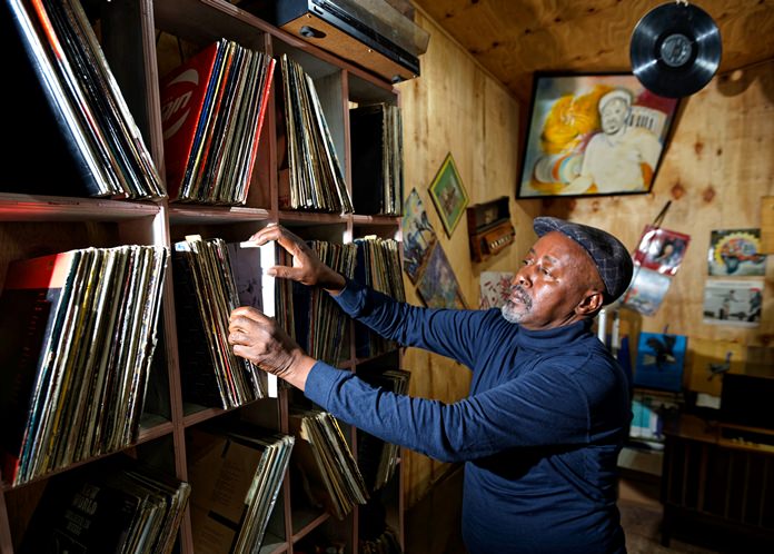 In this photo taken Thursday, March 1, 2018, James “Jimmy” Rugami looks through records inside his vinyl records stall in Kenyatta Market in Nairobi, Kenya. (AP Photo/Ben Curtis)