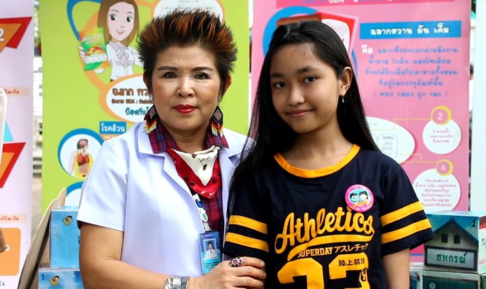 Pattaya Consumer Protection Office Director Buppa Songsakulchai awards a student with a healthy pin upon completion of the Little Food and Drug Project.