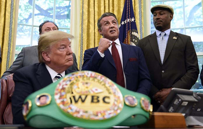 In this May 24, 2018 photo, President Donald Trump (left) and heavyweight boxer Lennox Lewis (right) watch as Sylvester Stallone gestures in the Oval Office of the White House in Washington. (AP Photo/Susan Walsh)