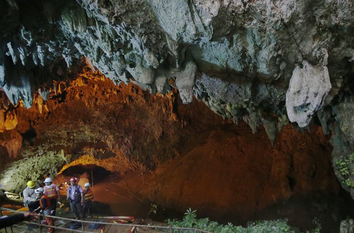 Rescue personnel walk out of the entrance to a cave complex where it's believed that 12 soccer team members and their coach went missing, Thursday, June 28, 2018, in Mae Sai, Chiang Rai province, in northern Thailand. A U.S. military team and British cave experts joined the rescue effort for 12 boys and their soccer coach missing for five days inside the cave being flooded by near-constant rains. (AP Photo/Sakchai Lalit)