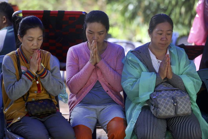 Relatives pray for missing young soccer team members and their coach in a cave during a rescue operation, Thursday, June 28, 2018, in Mae Sai, Chiang Rai province, northern Thailand. (AP Photo/Sakchai Lalit)