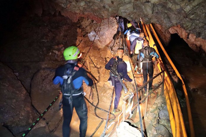 Thai rescue team members walk inside the cave where 12 boys and their soccer coach were trapped for 18 days. (Royal Thai Navy via AP)