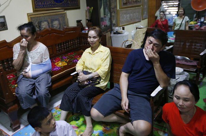 Banphot Konkum, the uncle of Duangpetch Promthep, one of the boys rescued from a flooded cave, second right, and other members of his family watch Duangpetch and the rest of the boys live on television at his home in Mae Sai district, Chiang Rai. (AP Photo/Sakchai Lalit)