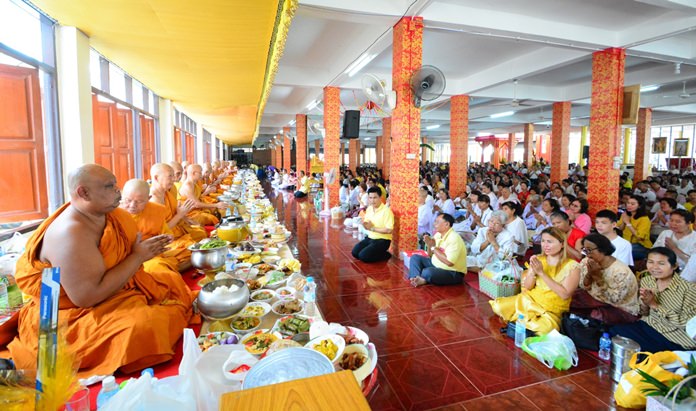 Devout Buddhists present alms at Wat Boonsamphan.
