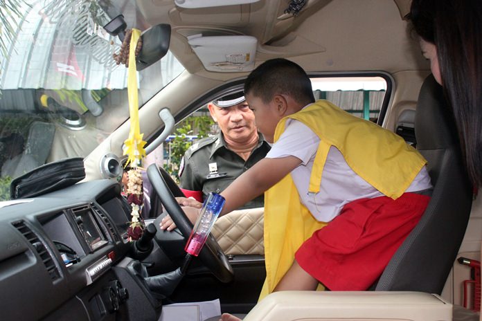 Traffic Pol. Maj. Aruth Sapanon teaches a child how to honk the horn to call for help.