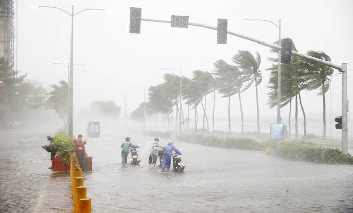 Motorists brave the rain and strong winds brought about by Typhoon Mangkhut which barreled into northeastern Philippines before dawn Saturday, Sept. 15, in Manila, Philippines. Nature expresses its fury in sundry ways. Two deadly storms - Hurricane Florence and Typhoon Mangkhut - roared ashore on the same day, half a world apart, but the way they spread devastation was as different as water and wind. (AP Photo/Bullit Marquez)