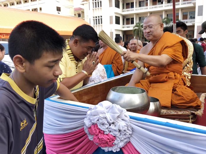 Tan Jao Khun Panya Rattanaporn, Abbot of Wat Chaimongkol Royal Temple sprinkles holy water on disciples.