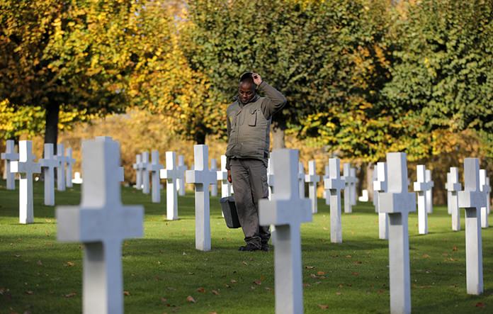 A cemetery employee walks between graves of American serviceman killed during WWI ahead of celebrations of the WWI centenary at the American Cemetery in Suresnes, on the outskirts of Paris. (AP Photo/Vadim Ghirda)
