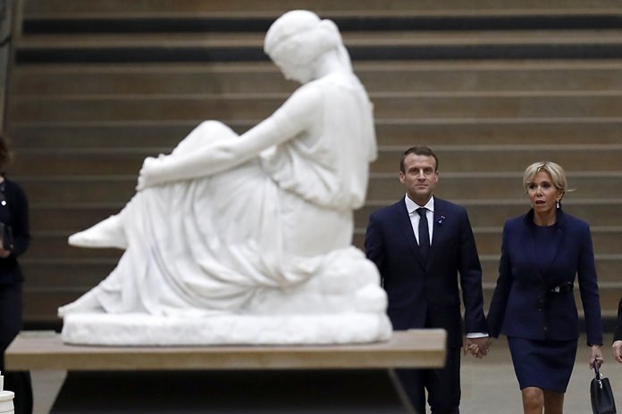 French president Emmanuel Macron and his wife Brigitte Macron arrive at the official dinner on the eve of the international ceremony for the Centenary of the WWI Armistice of 11 November 1918 at the Orsay Museum in Paris. (Ian Langsdon/Pool Photo via AP)