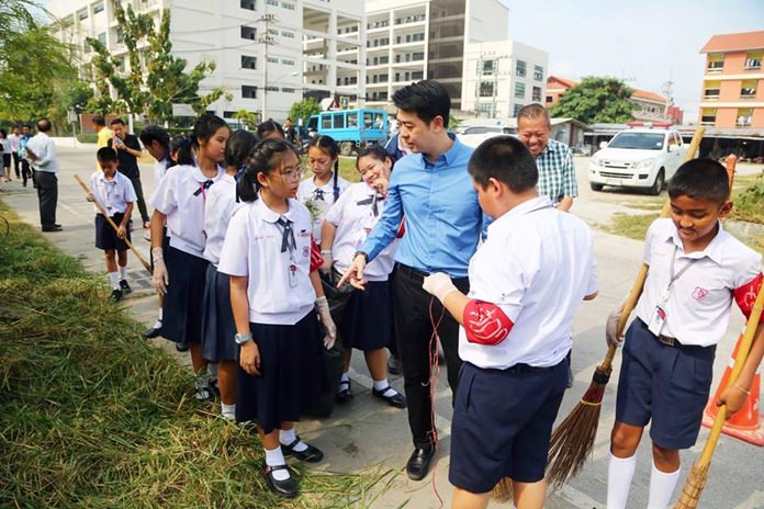 Students from Aksorn Suksa School joined Pattaya sanitation workers in collecting garbage and cleaning the area behind Banglamung Hospital.