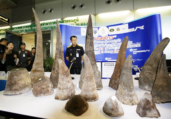 In this March 14, 2017, file photo, Thai Customs officers stand behind seized rhino horns at the customs office at Suvarnabhumi airport. (AP Photo/Sakchai Lalit)