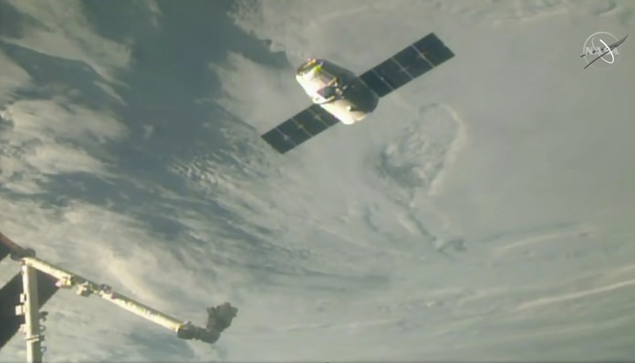 In this image taken from NASA Television, the SpaceX Dragon cargo spacecraft full of Christmas goodies approaches the robotic arm for docking to the International Space Station, Saturday, Dec. 8, 2018. (NASA TV via AP)