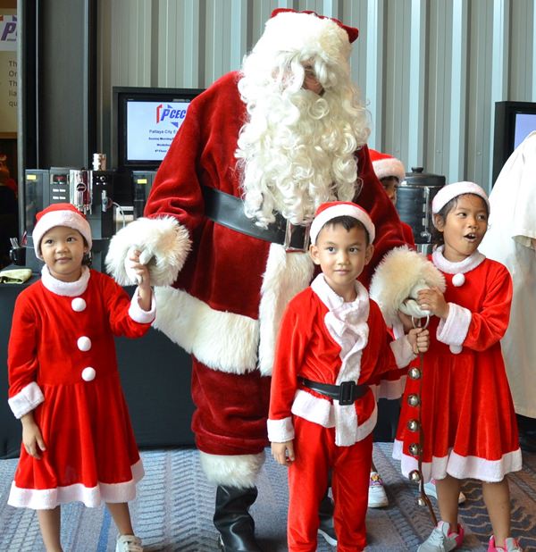 Several members of the younger Pattaya Orphanage Choir happily welcome Father Christmas to the PCEC festivities.
