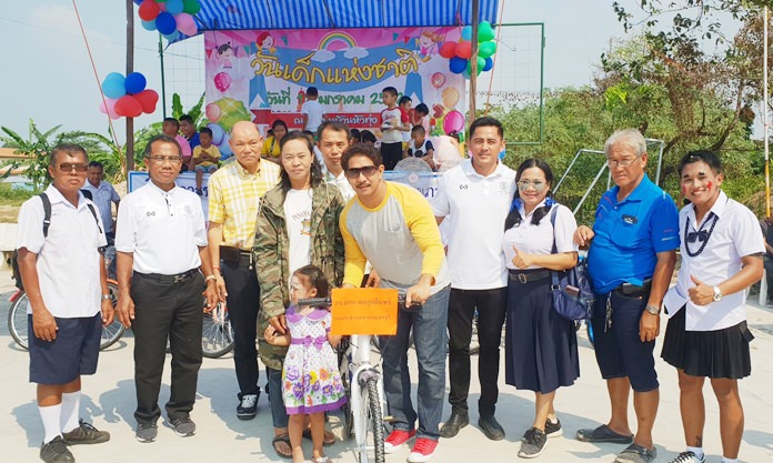 Chonburi Provincial Councilor Sakol Phonlookin and friends give away bicycles to children in Naklua’s Hua Tung Community.