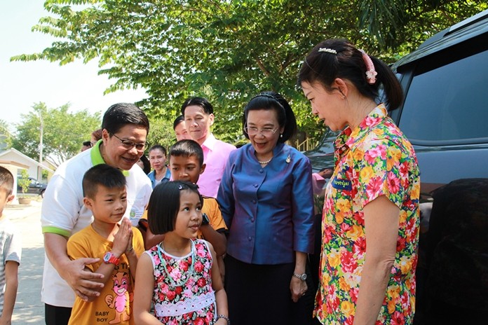 Children, along with center and government officials, walk Supaporn out to her awaiting van to say goodbye and thank her for a wonderful day.