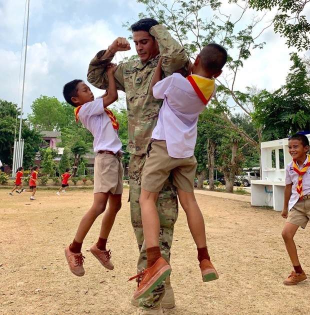 Sgt. Antonio Martinez, US Army reservist assigned to the 416th Civil Affairs Battalion (Airborne), plays with two Thai school children at Ban Wang Mai Daeng School during Cobra Gold 19. (U.S. Navy photo by Lieutenant Junior Grade Travis Weger)
