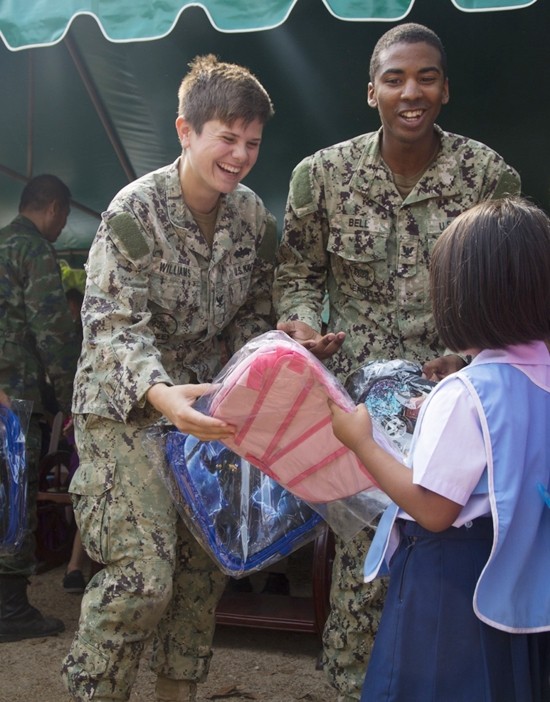 U.S. Navy Petty Officer 3rd Class Autumn Williams, Left, and Petty Officer 3rd Class Jamarcus Bell, Right, help hand out backpacks to the students from the Ban Man Kroi School during exercise Cobra Gold 19 at Ban Man Kroi School, Rayong. Williams, a native of Poca, West Virginia and Bell, a native of Orlando, Florida are builders with Naval Mobile Construction Battalion 3. (U.S. Marine Corps photo by Lance Cpl. Kenny Nunez.)