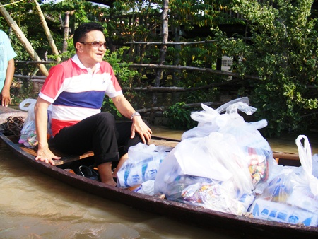 Deputy Mayor Wutisak Rermkitkarn travels by boat to help deliver supplies to flood victims.