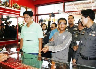 Bunliam Luechailam shows police and the press how he held up a gold shop.