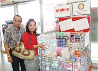 A benevolent couple places packets of foodstuffs in the collection area at Makro Pattaya Branch, for distribution to victims of the floods in the country.