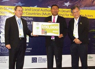 (L to R) Peter Köppinger (left) and Dr. Paul Chamnien Vorratnchaiphan (right) present Prai Pattano with a check for 100,000 baht to support flood victims in Hat Yai.