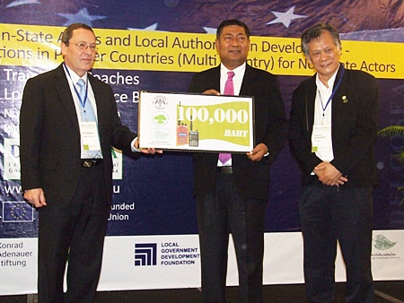 (L to R) Peter Köppinger (left) and Dr. Paul Chamnien Vorratnchaiphan (right) present Prai Pattano with a check for 100,000 baht to support flood victims in Hat Yai. 