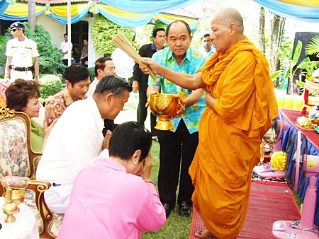 Phra Khru Visuthipiyakorn blesses General Kanit and Khunying Busyarat by sprinkling them with lustral water, calling on all that is sacred to give them good health and prosperity.